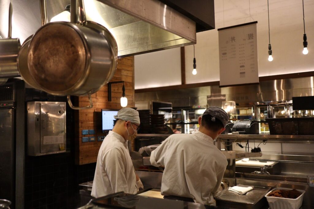 Two chefs working in a professional kitchen, highlighting culinary expertise and teamwork.